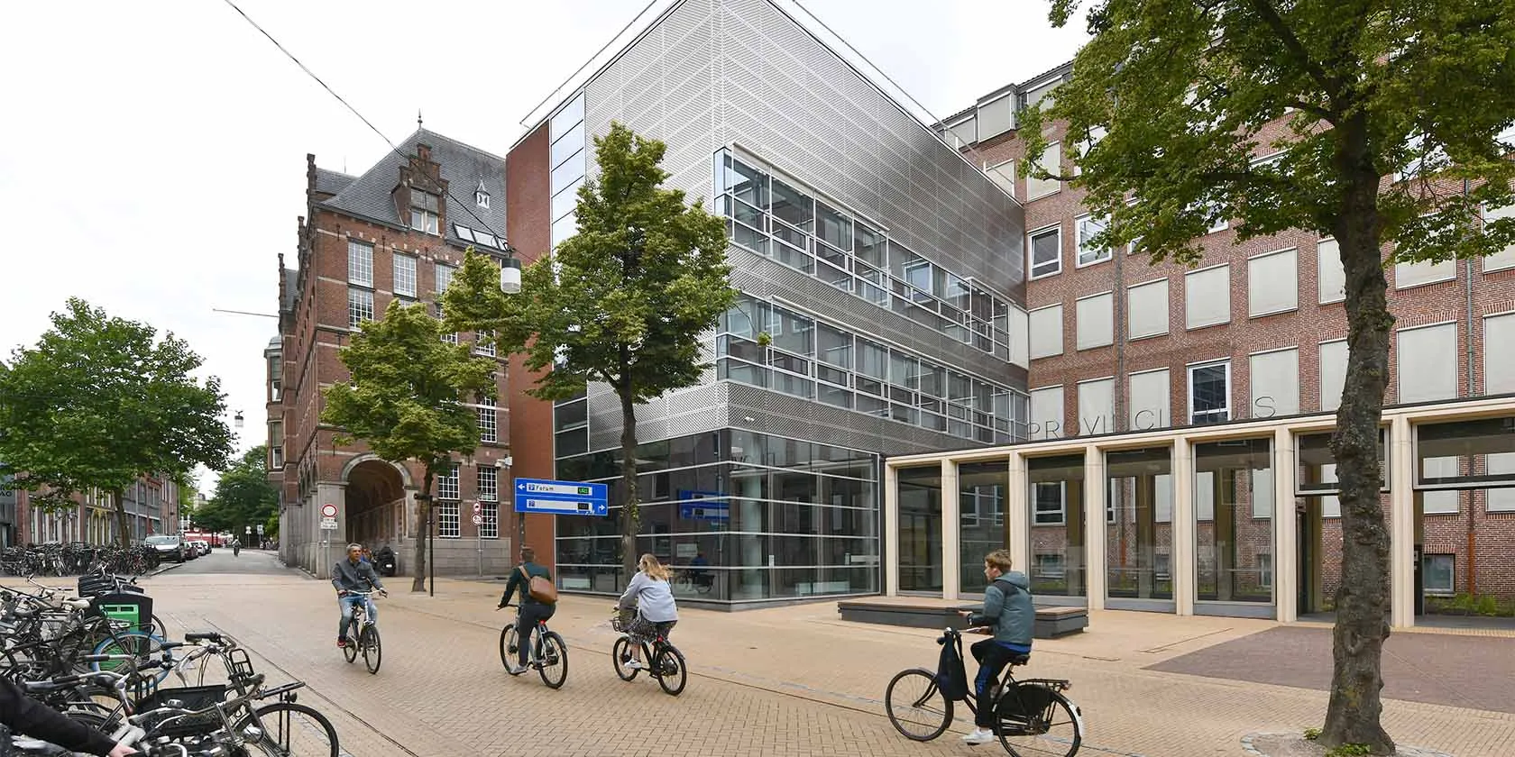 Vier mensen fietsen voor een gebouw